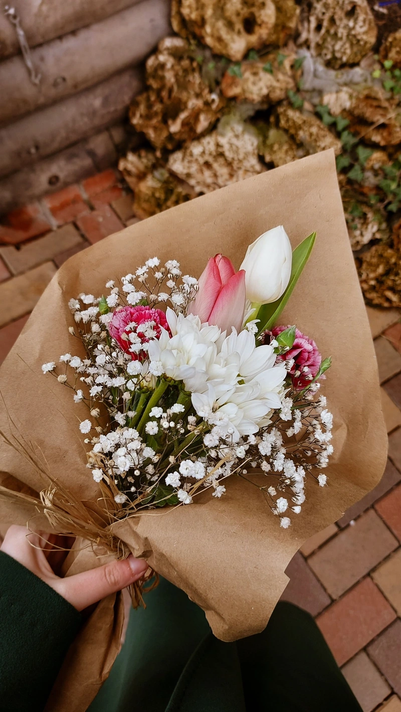 Phone photo: wrapped tulips, kraft paper and gypsophila