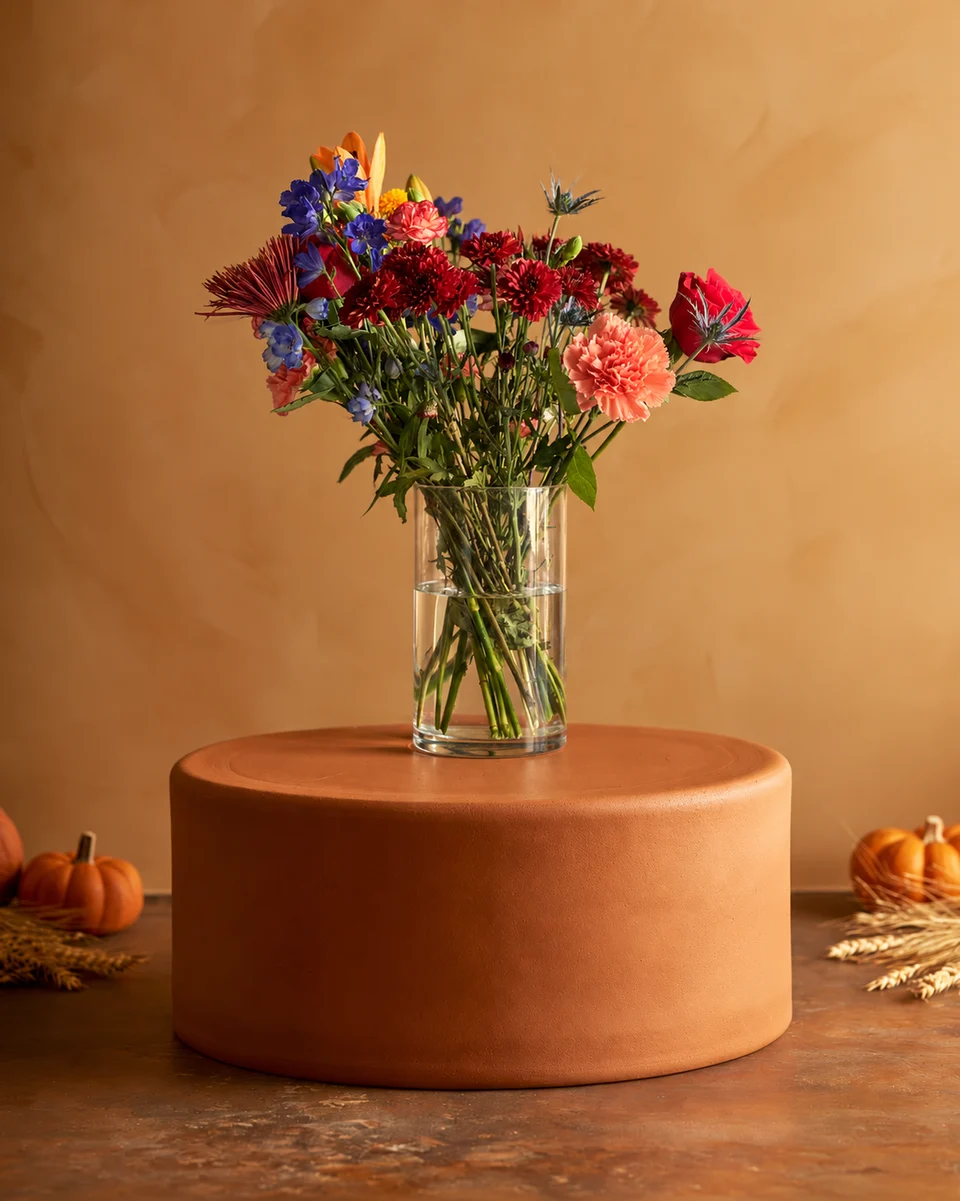Illustrative test example: Mixed arrangement in a glass vase on a terracotta pedestal with small pumpkins and wheat